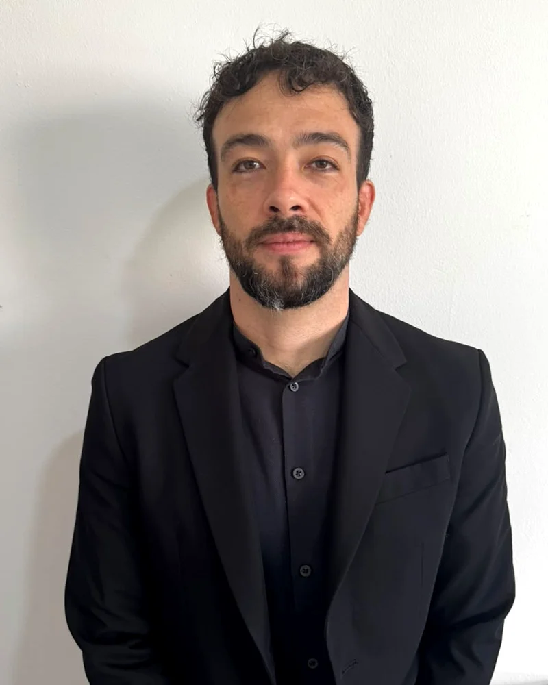 William Kabelka, de saco negro, con fondo claro